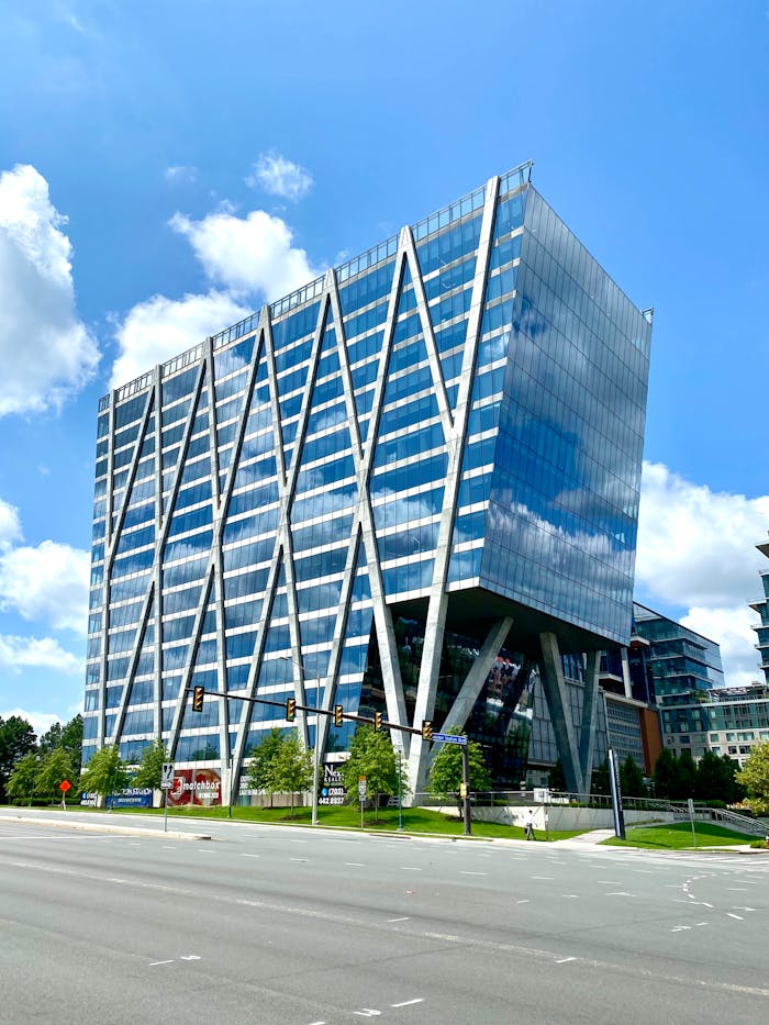 gallery-2 A striking modern office building with a geometric glass facade in an urban setting.
