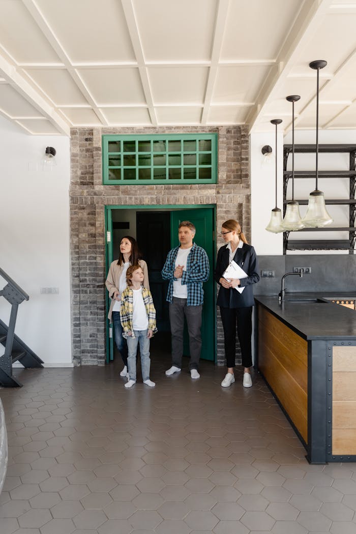 services-02 A family touring a modern home interior with a real estate agent, considering a purchase.