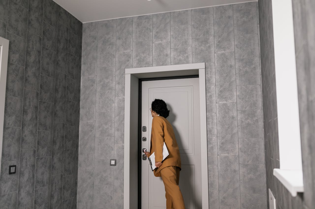 gallery-1 Real estate agent in business attire inspecting a modern home's entrance.