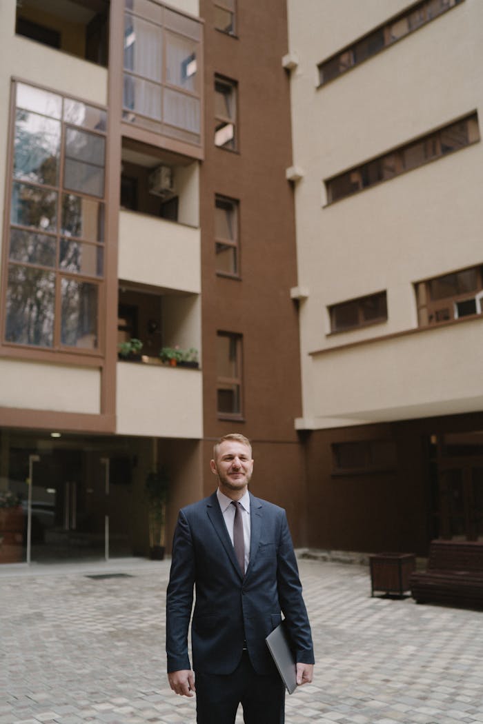 gallery-4 Businessman in a suit standing confidently outside a modern building, perfect for real estate themes.